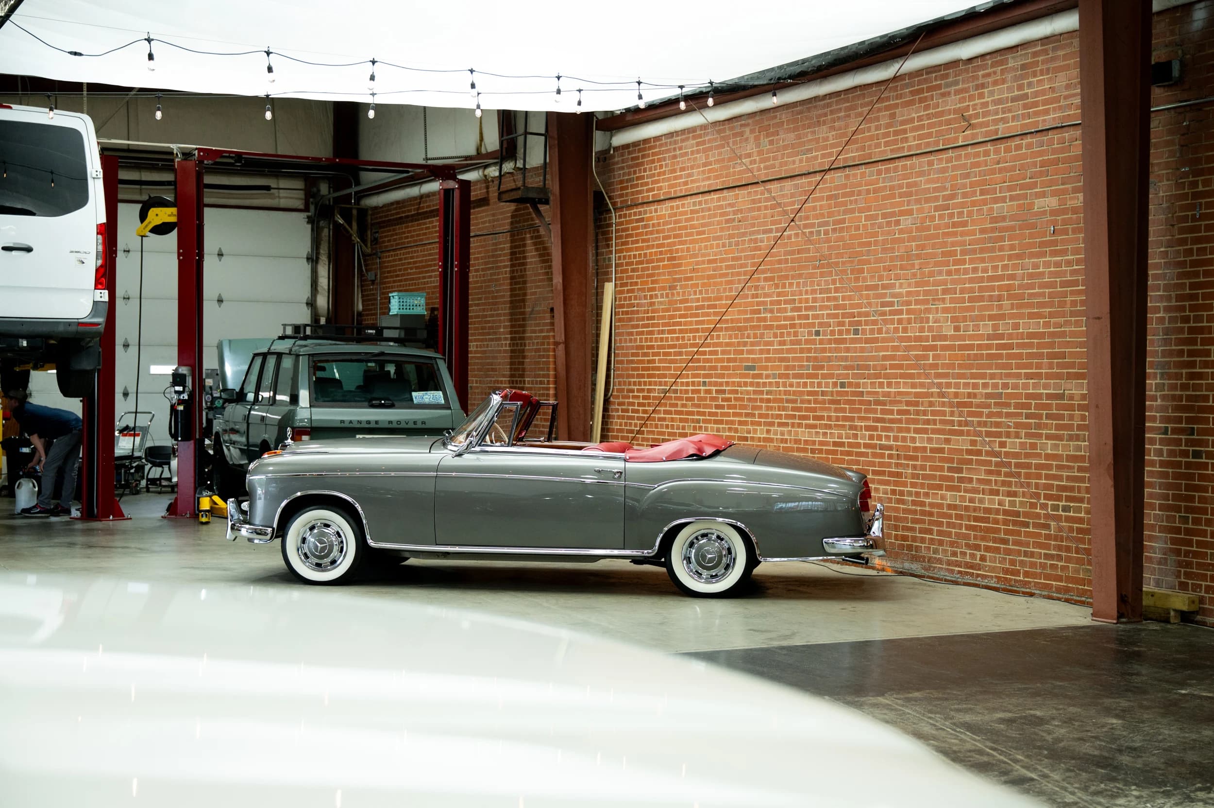Silver Mercedes-Benz convertible beside the brick wall in the Speed House workshop