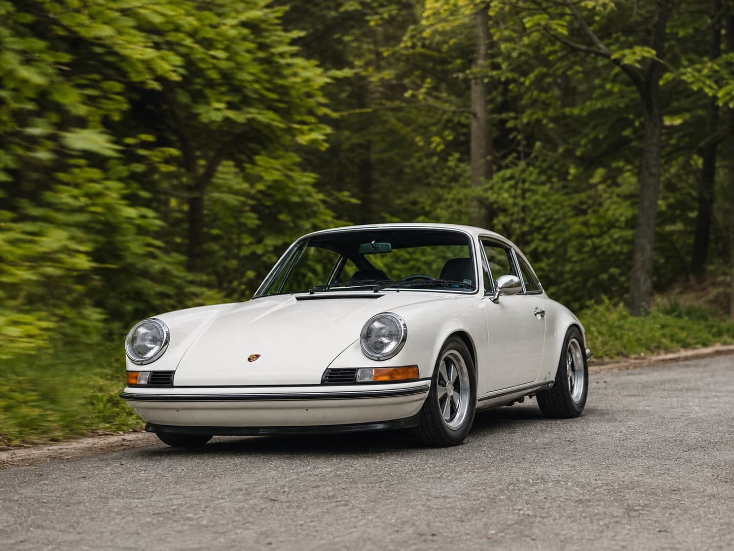 White 1973 Porsche 911 S on a wooded road