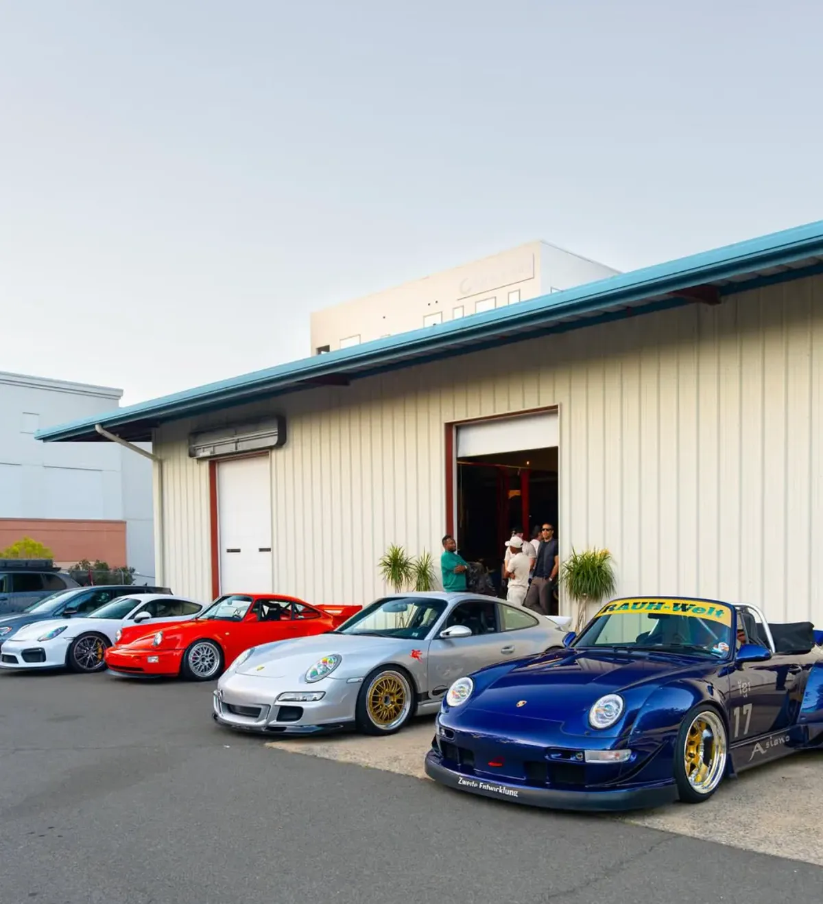 Red Porsche and guests outside the open Speed House garage